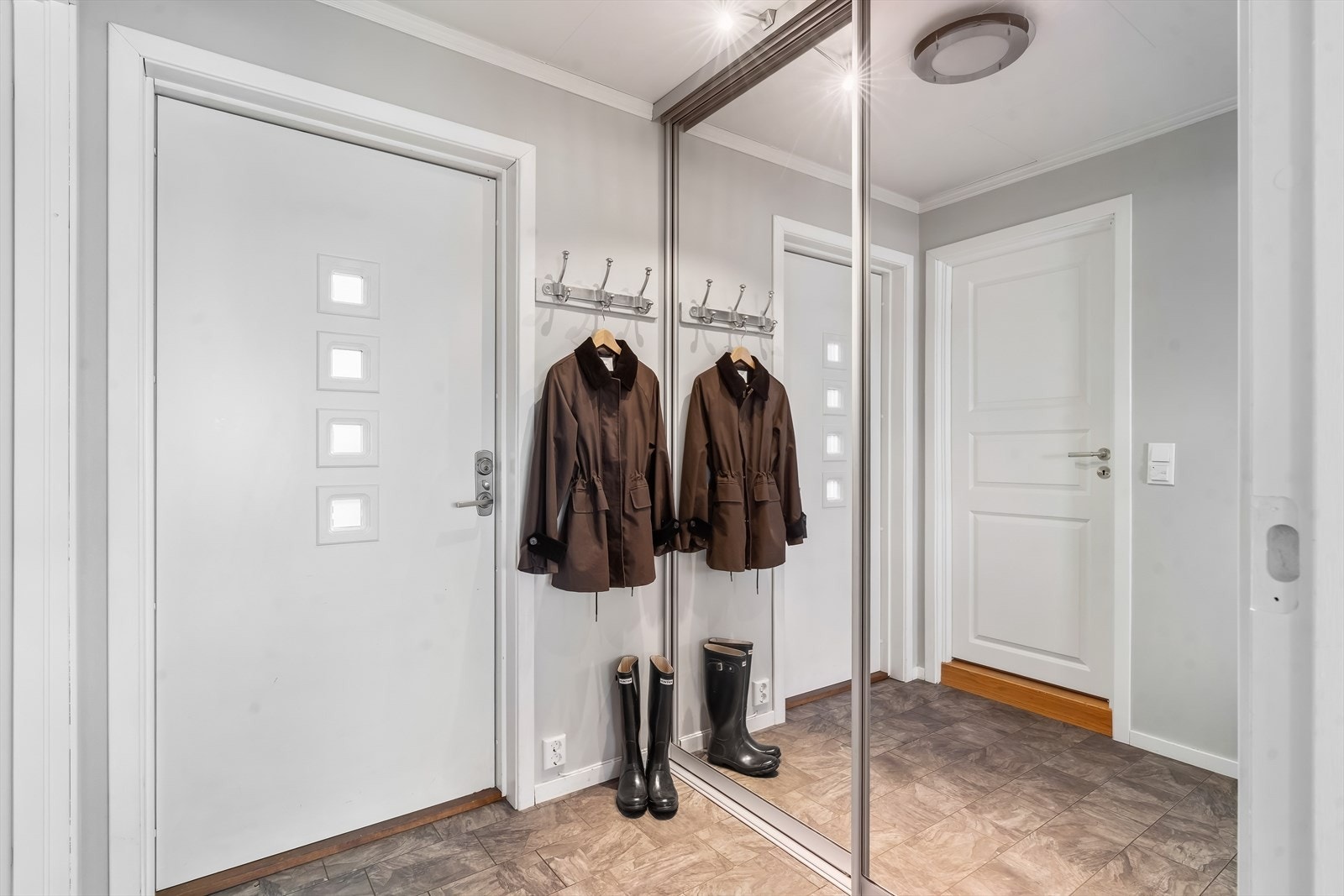 I entréen er det plass til å henge fra seg yttertøy i romslig skyvedørsgarderobe med speilfronter. Galleribilde