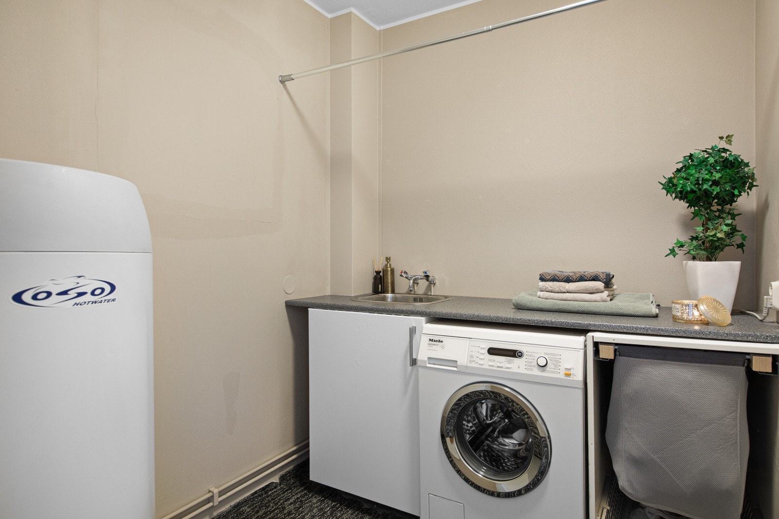 Leiligheten har et separat vaskerom med opplegg for vaskemaskin og praktisk arbeidsbenk. Galleribilde