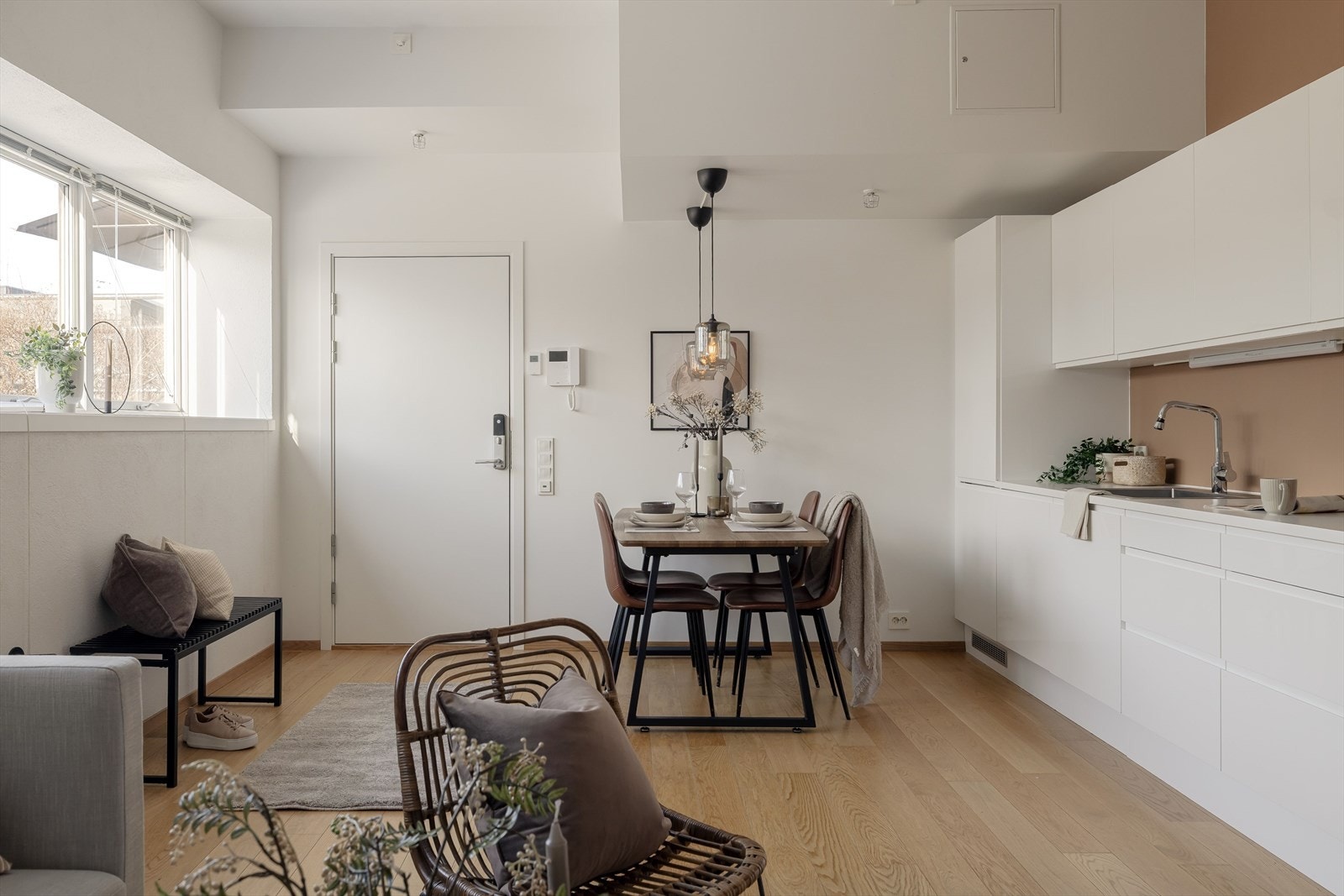 Leiligheten har en åpen stue- og kjøkkenløsning med en lys og moderne kjøkkeninnredning med hvite, glatte fronter. Galleribilde