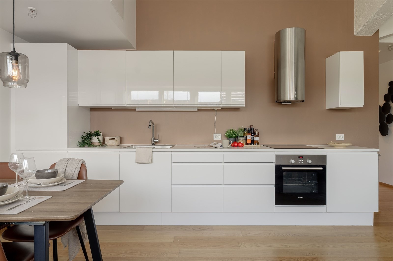 Benkeplate av laminat med nedfelt oppvaskkum. Hvitevarer som stekeovn, platetopp, oppvaskmaskin og kjøleskap med fryser er integrert og medfølger i handelen. Galleribilde