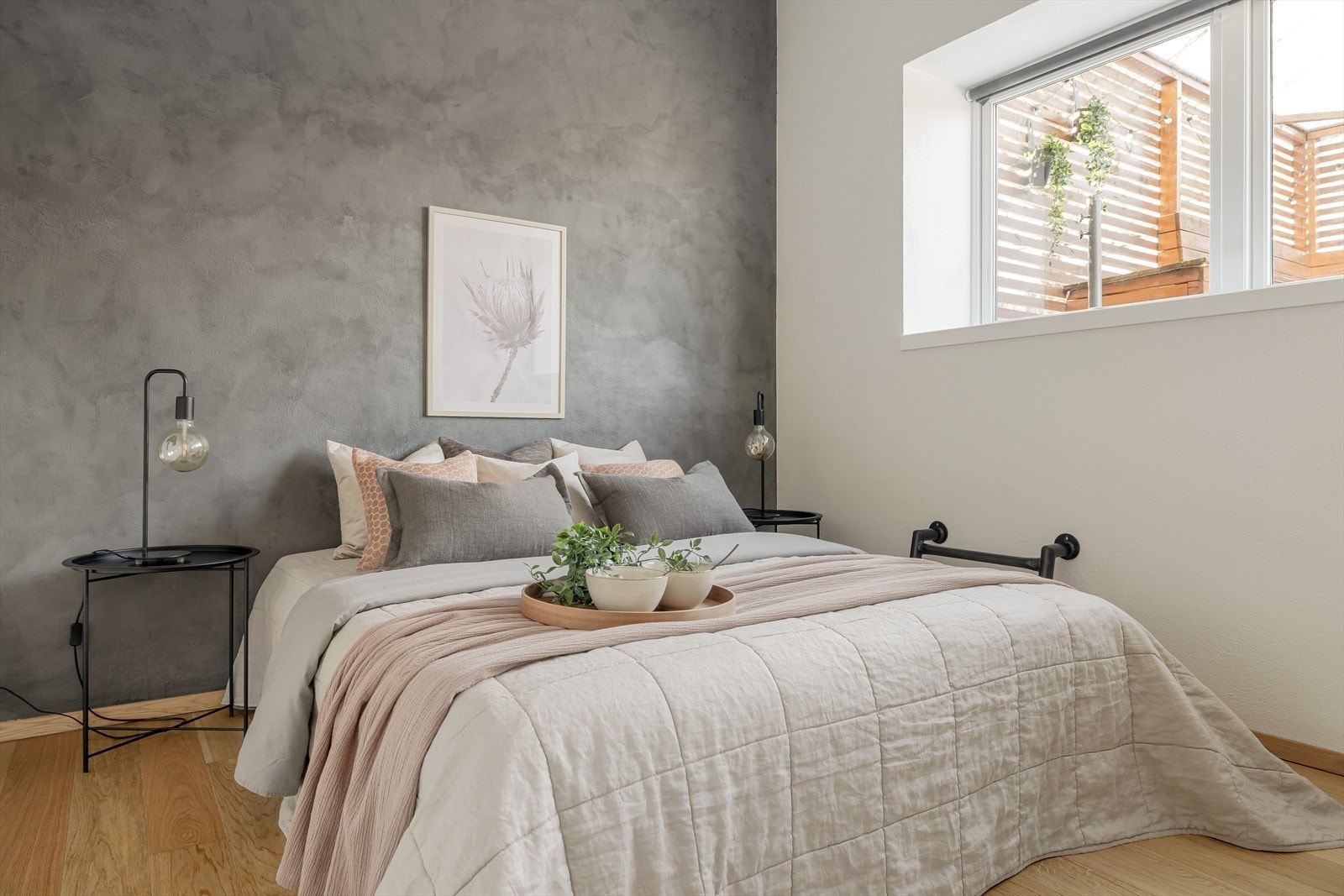 Leiligheten har et lyst og luftig soverom med hvitmalte vegger i kombinasjon med en kontrastvegg med kalkmaling. Galleribilde