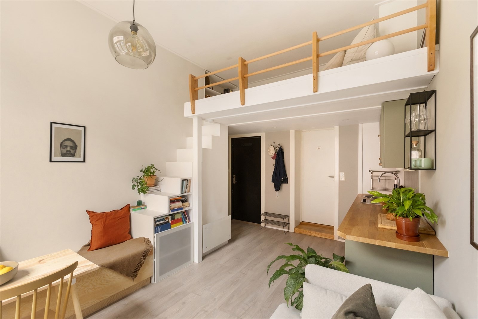 Fra stuen leder en plassbygget trapp opp til hemsen, og den fungerer samtidig som en dekorativ og praktisk bokhylle. Galleribilde