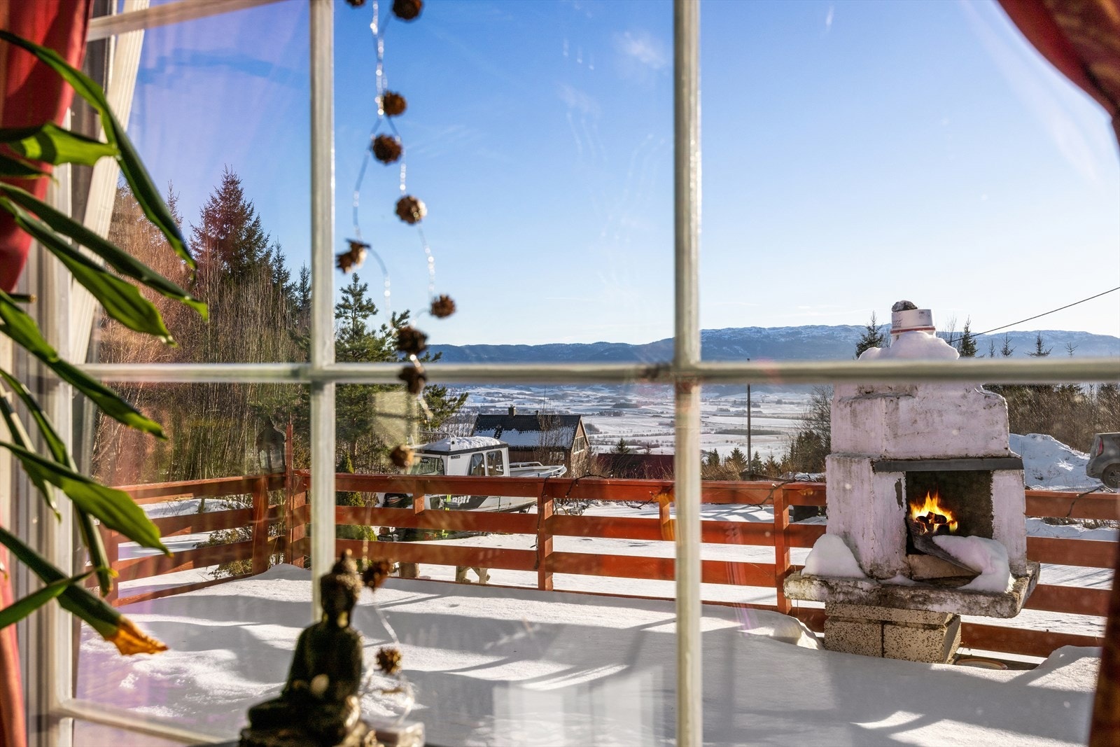 Utsikten fra stuevinduet strekker seg ut over terrassen og det omkringliggende landskapet. Galleribilde