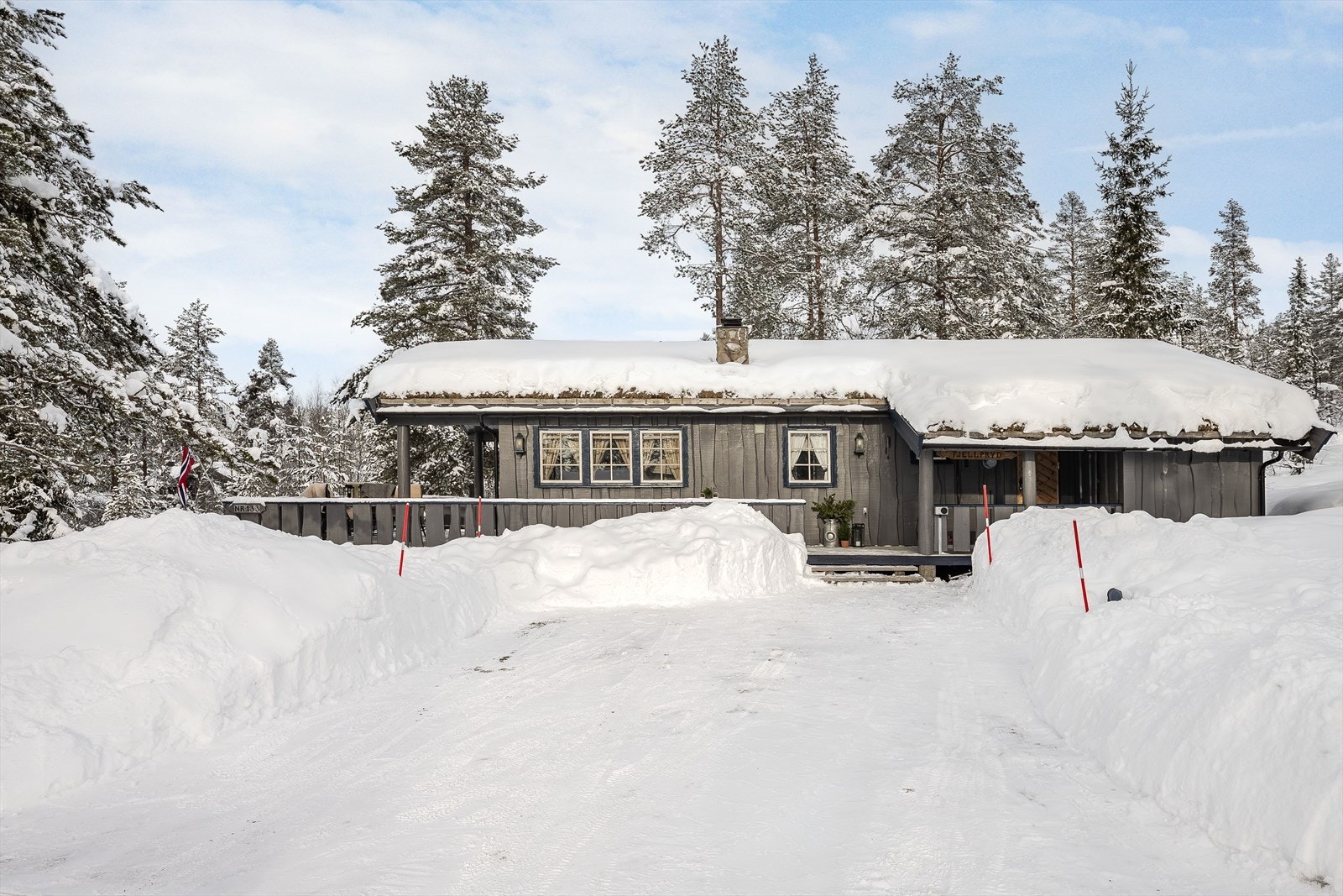 Hytta har parkering på egen tomt og det ble i 2023 montert elbil-lader på hytteveggen. Galleribilde