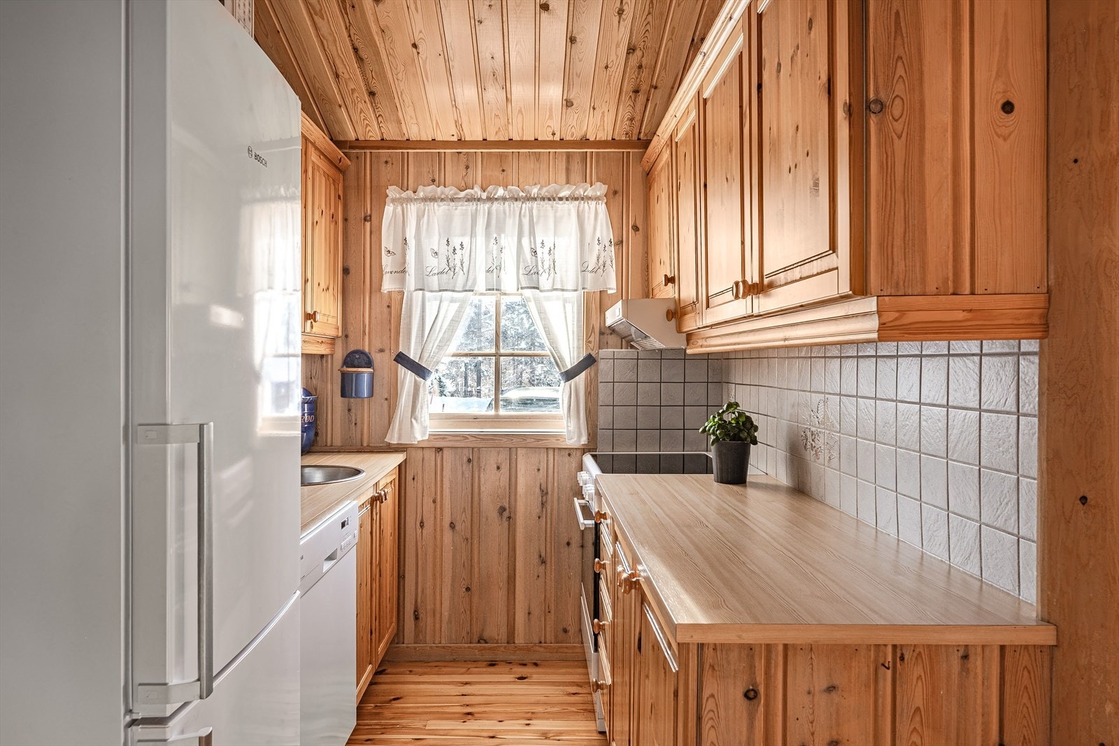 Kjøkkenet har åpen løsning for hvitevarer som komfyr, kjøleskap og oppvaskmaskin. Galleribilde