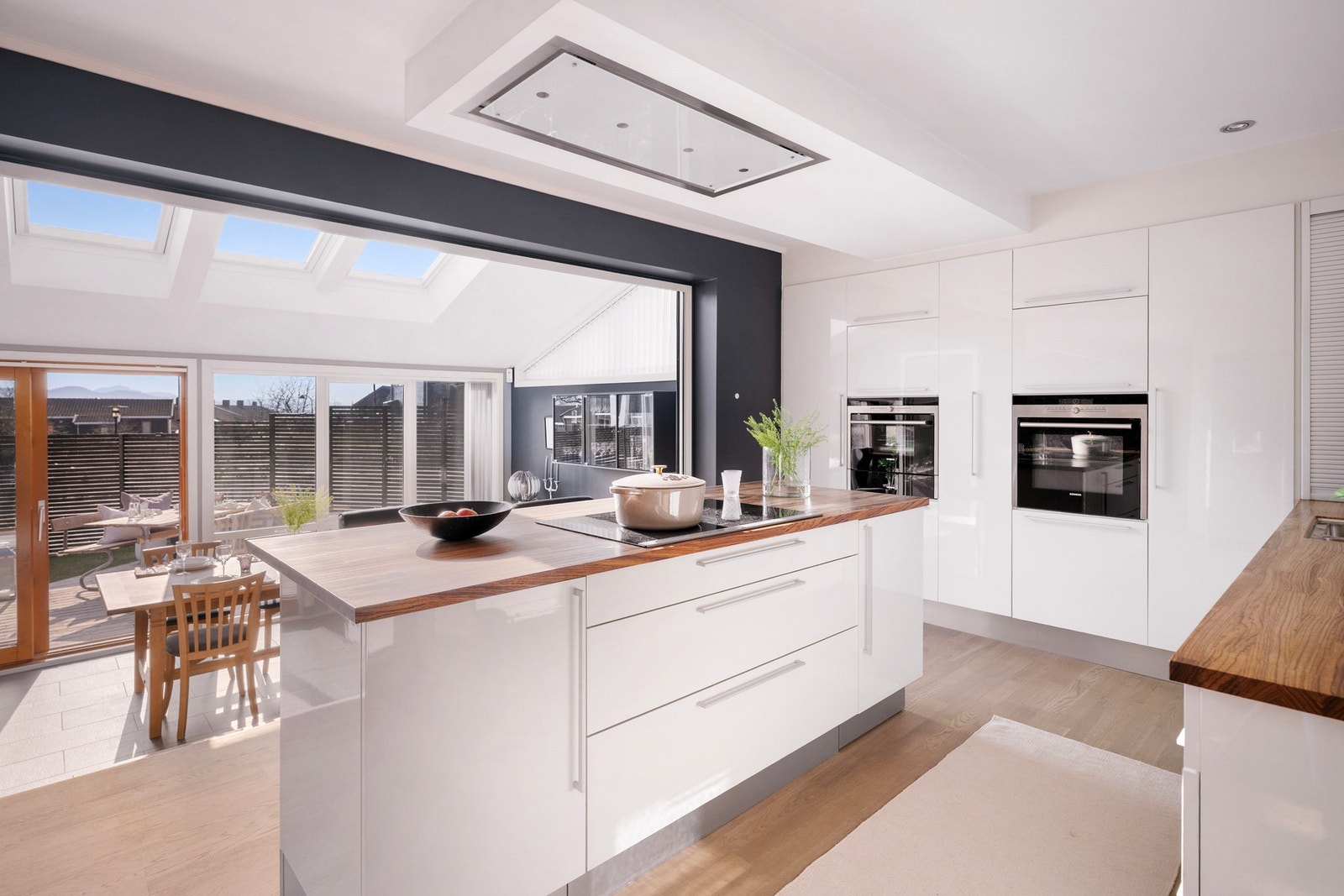 Integrert ventilator i tak styres med fjernkontroll, samt gode uttrekksløsninger i både høyskap og hjørneskap. Galleribilde