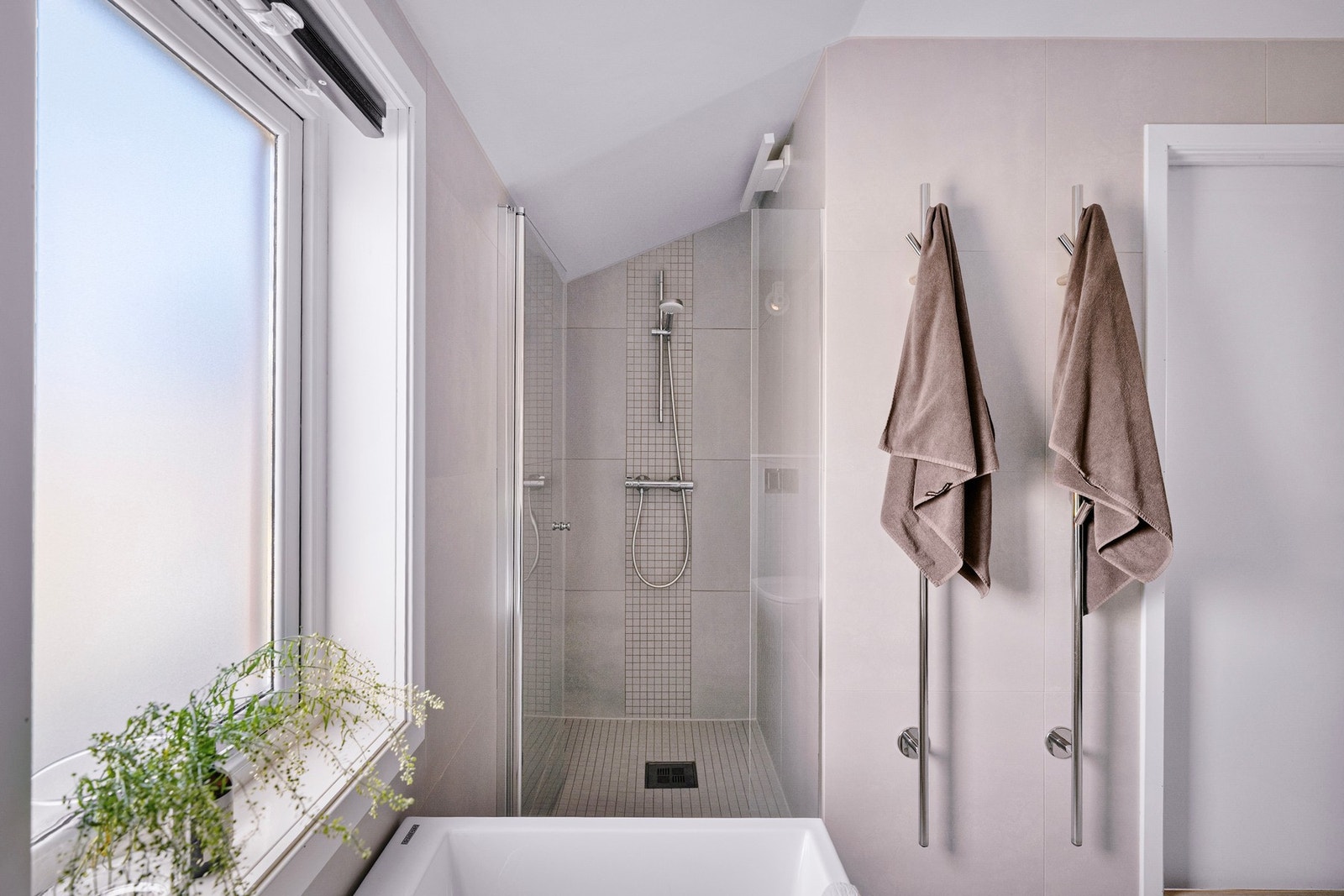 Badet er moderne med store fliser, romslig dusjsone og dobbel servant. Galleribilde