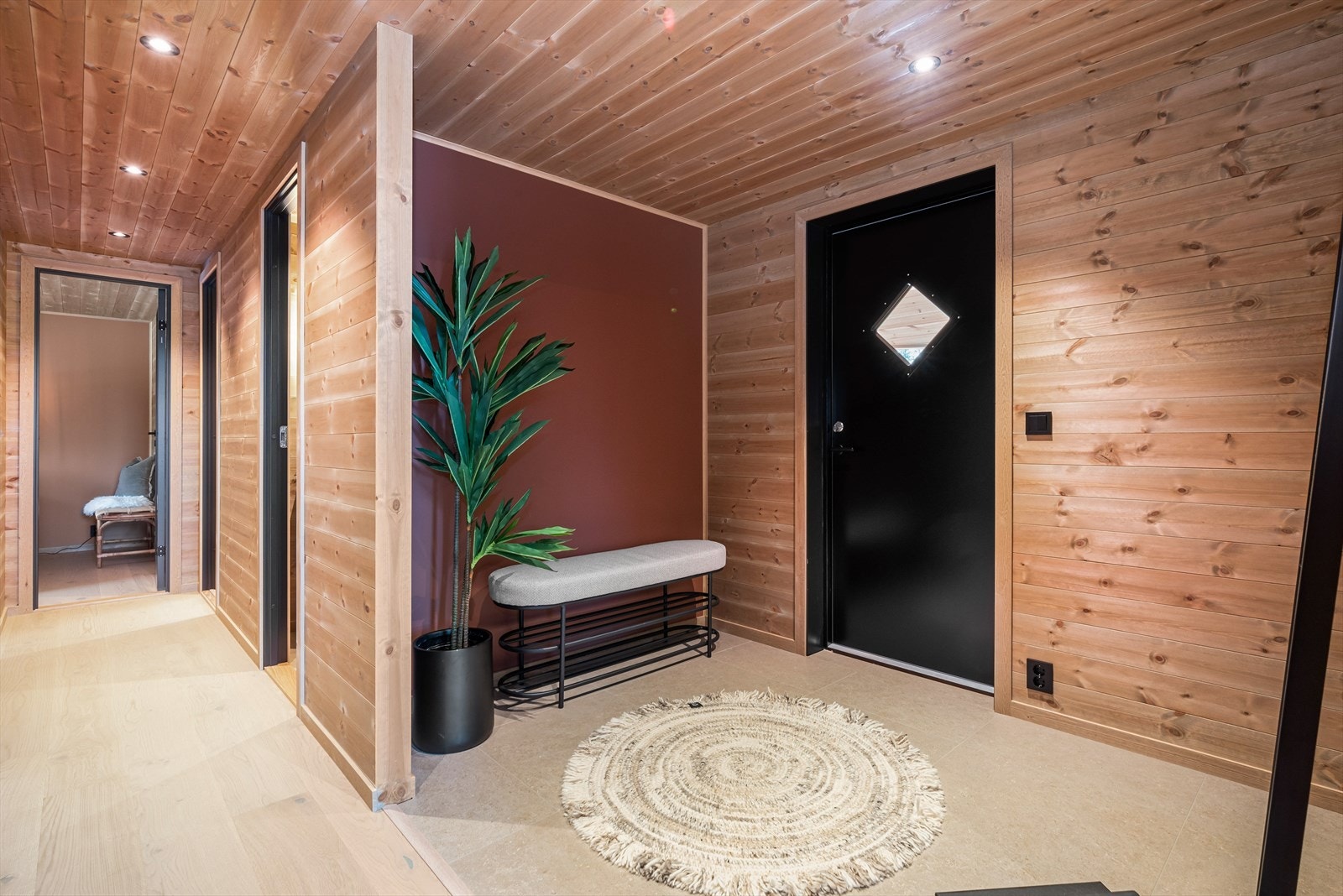 Den innbydende gangen har både 1-stavs parkett og store, lysegrå fliser på gulvet. Galleribilde