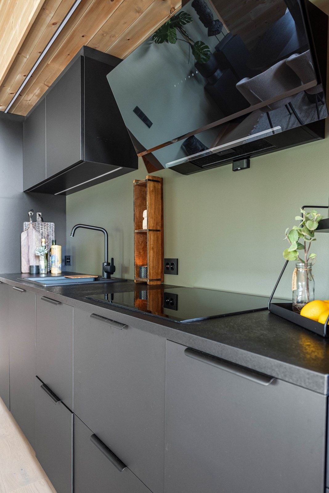 Over kokesonen har kjøkkenet en komfyrvakt og en stilig ventilator. Galleribilde