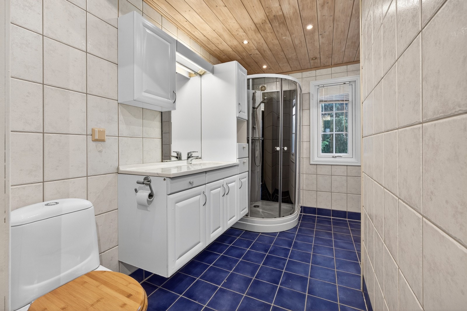 Eldre bad i boligens 1. etasje, fra 2002 iht. tidligere tilstandsrapport. Badet har flislagte overflater og varmekabler i gulv. Galleribilde