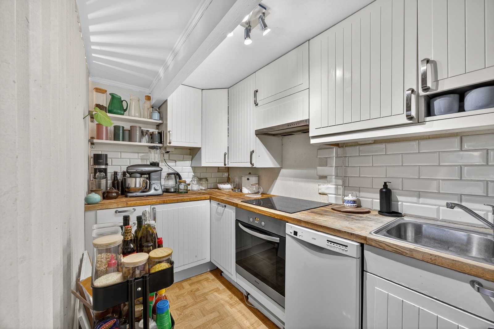 Stue og kjøkken er i delvis åpen løsning. Lyst kjøkken med profilerte fronter og heltre benkeplate med nedfelt kum i rustfritt stål. Opplegg for oppvaskmaskin. Galleribilde