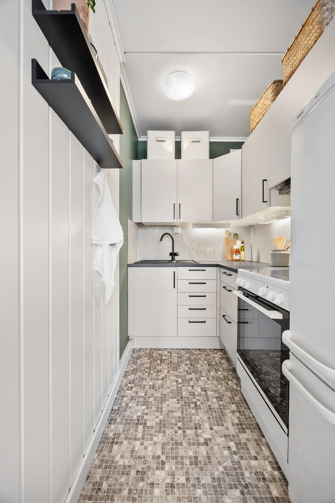 Kjøkkenet er praktisk innredet med god skapplass og frittstående hvitevarer. Galleribilde