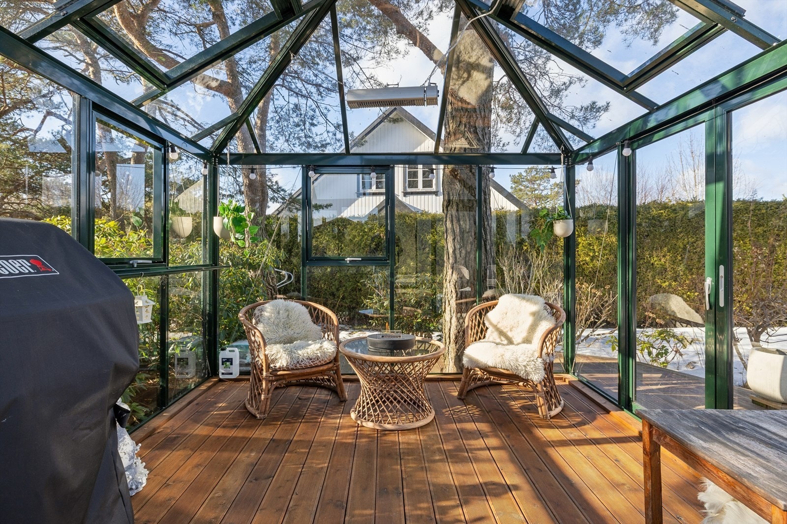 Inne i hagestuen er det lunt og hyggelig, med utsikt til den grønne hagen. Galleribilde