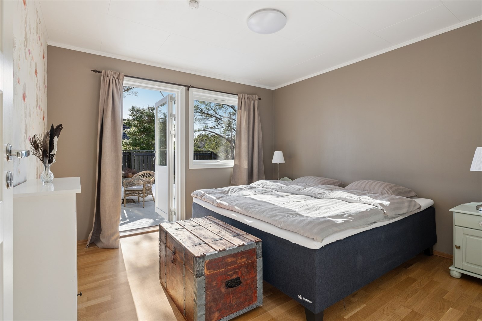 Fra soverommet i 1. etasje er det utgang til terrassen, som binder inne- og uterom sammen. Ny balkongsdør i 2025. Galleribilde