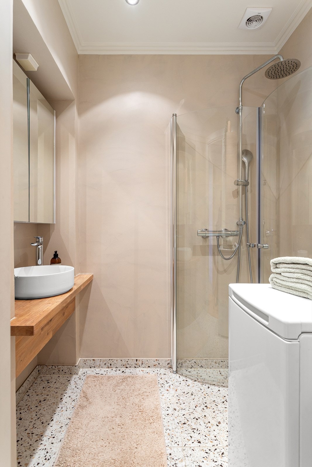 Lekkert bad med microsement på vegger, fliser på gulv og malt tak. Membran og fliser ble lagt nytt i 2023. Dusjen er plassert i hjørnet og har regn- og håndholdt dusjarmatur samt dusjvegger. Galleribilde