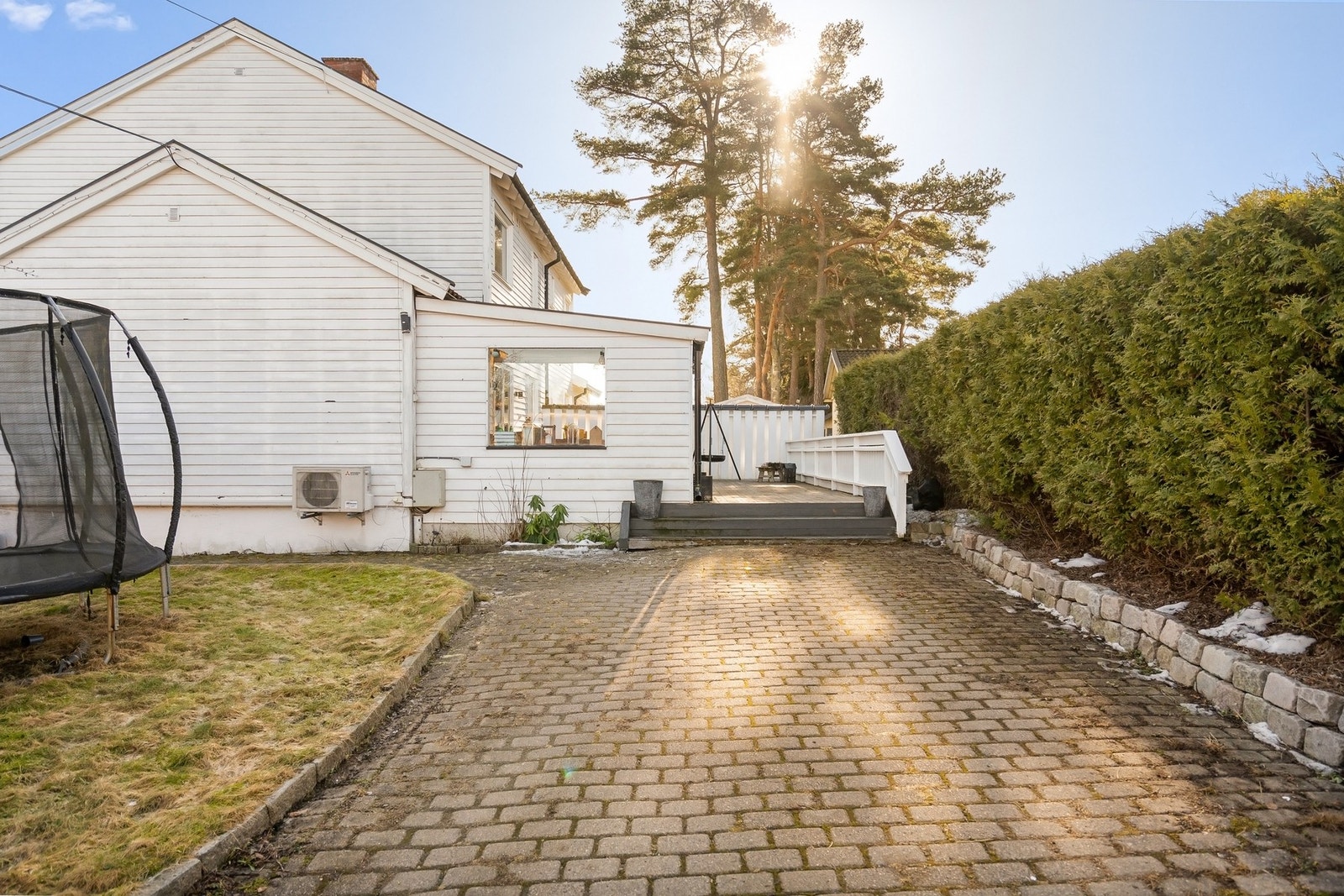 Gårdsplass med belegningsstein, og fint skjermet med tujahekk. Galleribilde