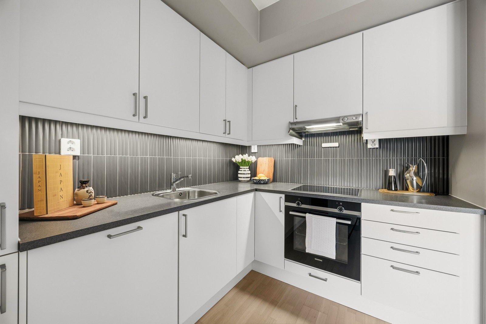 Over benkeplaten er det moderne fliser, samt led-belysning under overskapene. Galleribilde