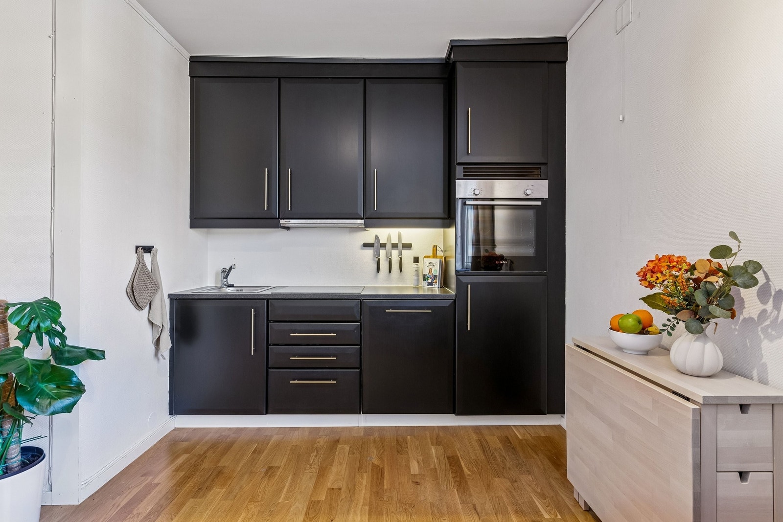 Pent kjøkken med god skapplass, oppvaskmaskin, stekeovn, platetopp og kjøleskap. Galleribilde