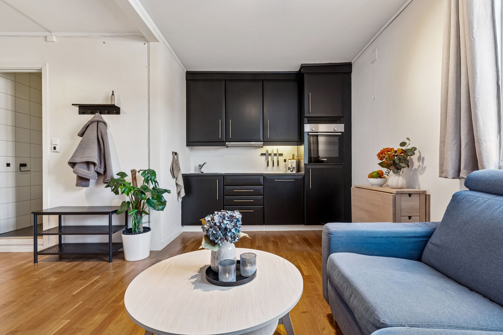 Mellom kjøkken og sittegruppe er det plass til spisebord og stol Galleribilde