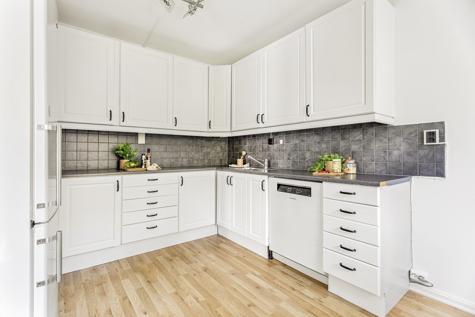 Kjøkkeninnredningen har profilerte fronter som gir et klassisk og tidløst preg, kombinert med en slitesterk laminatbenkeplate. Galleribilde