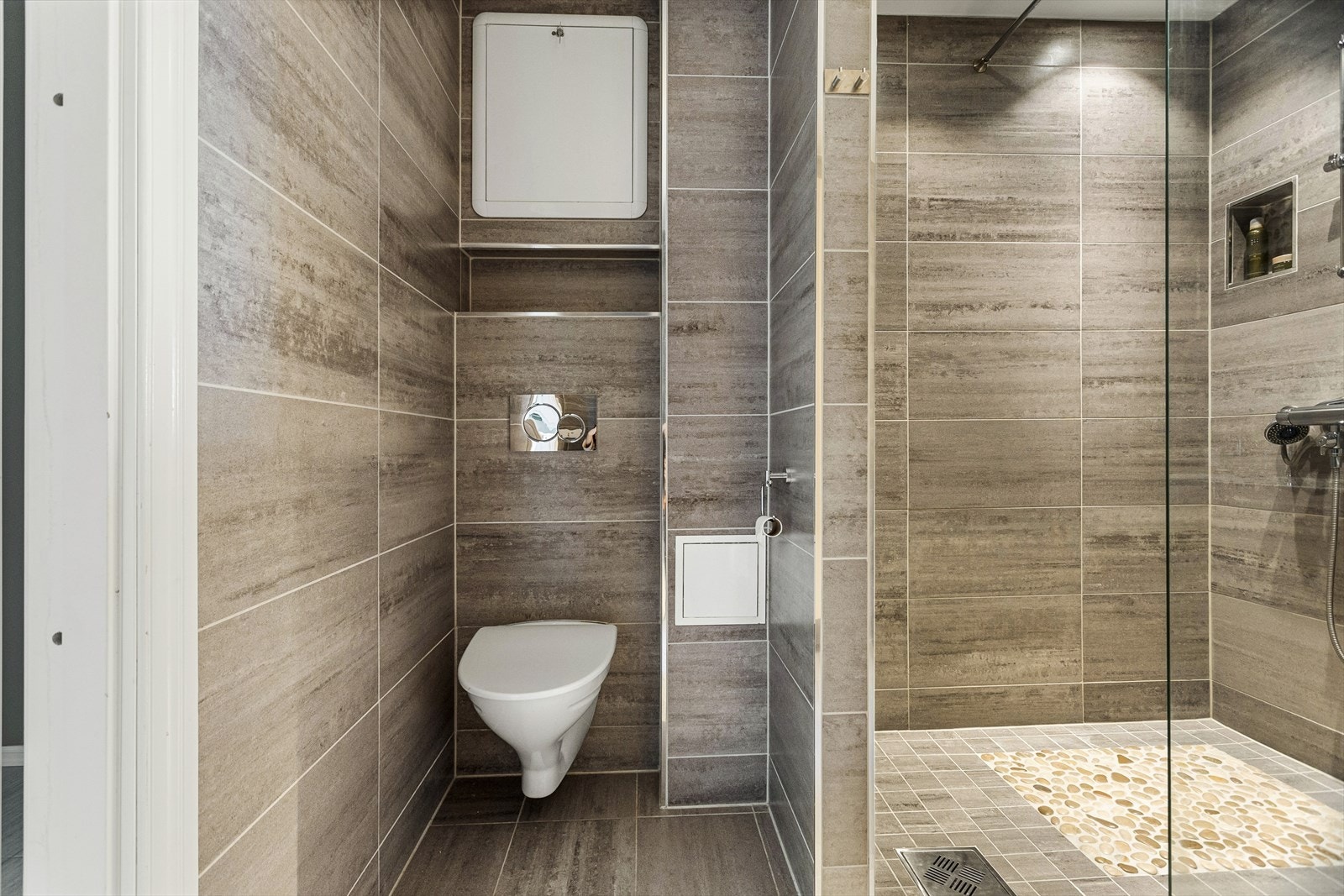 Rommet er praktisk innredet med baderomsinnredning med nedfelt servant, vegghengt toalett, dusjvegg samt opplegg for vaskemaskin. Galleribilde