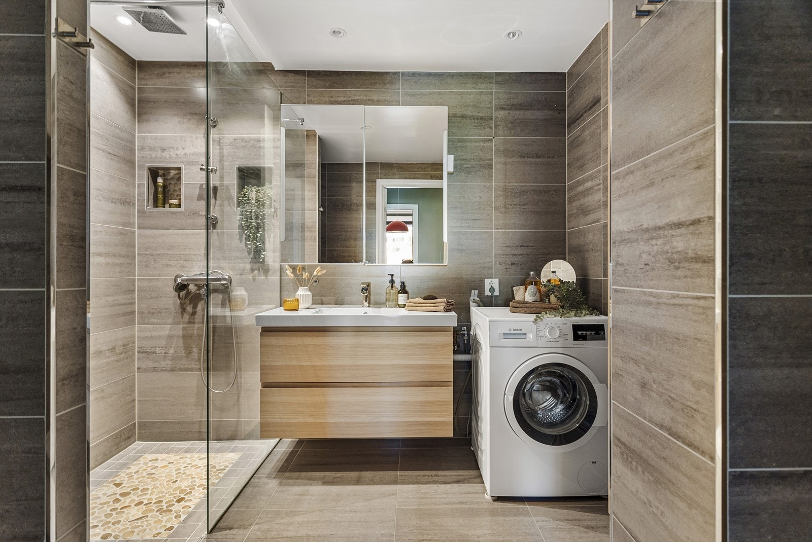 Badet er moderne og helfliset, med behagelige varmekabler i gulvet som gir ekstra komfort. Galleribilde