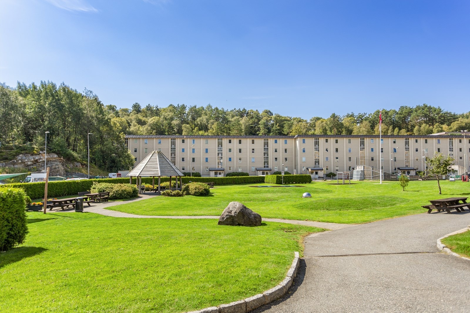 Tomten er pent opparbeidet med romslige parkeringsarealer, velstelte grøntområder, lekeplasser og hyggelige sittegrupper. Gjennomført beplantning gir området et grønt, harmonisk preg og inviterer til både avslapning og hyggelige møter med naboer. Galleribilde