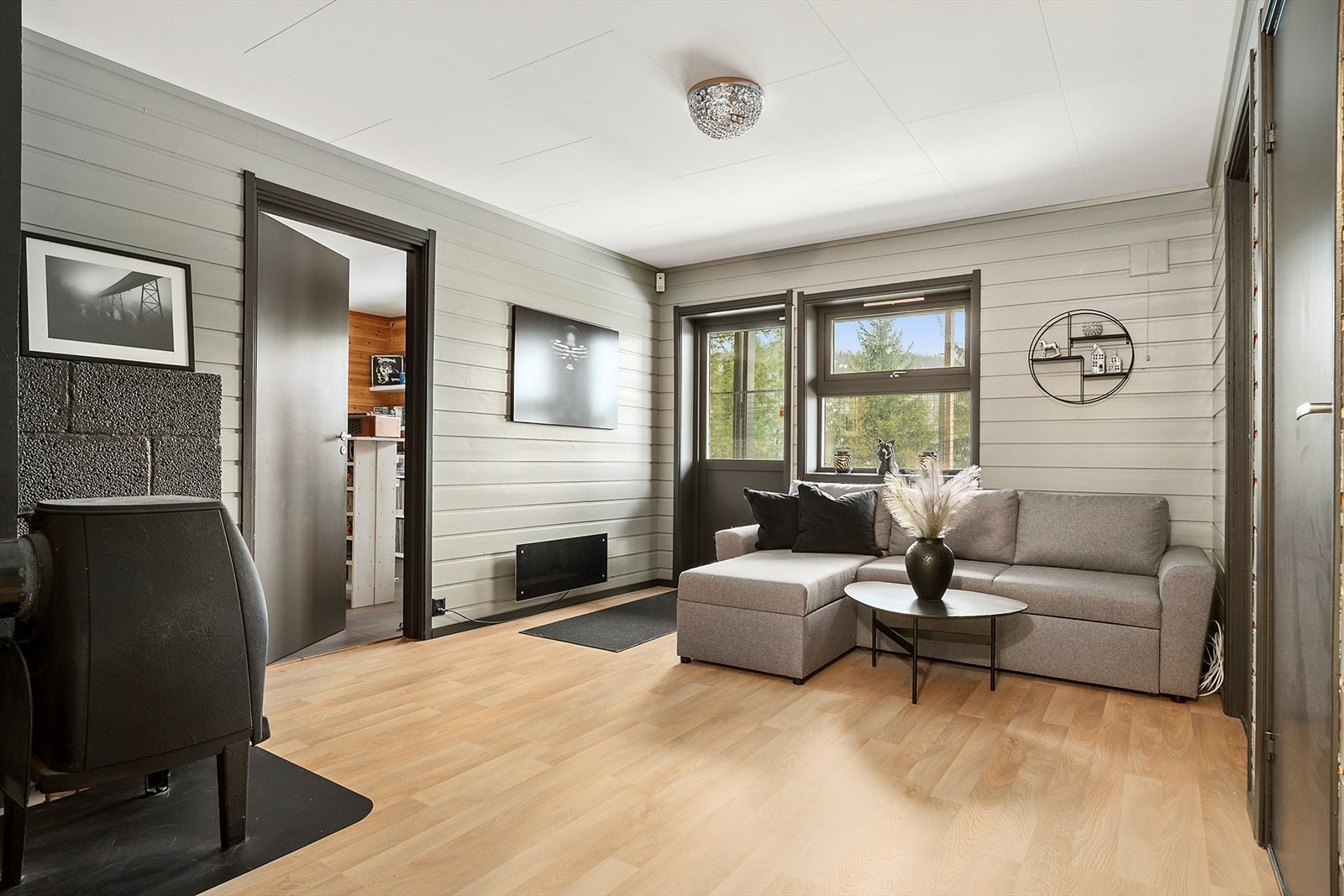 Kjellerstua er i gråmalt, panelt utførelse og er utstyrt ned vedfyringsovn. Galleribilde