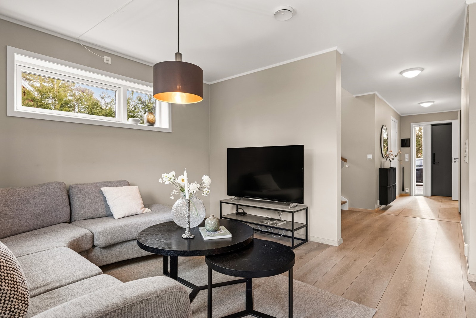 En lekker og romslig stue som utgjør boligens naturlige samlingspunkt. Galleribilde