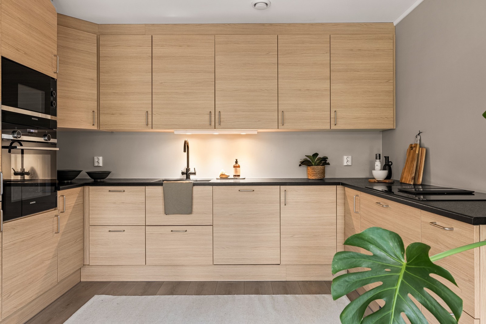 Stort og flott kjøkken som har godt med skap- og benkeplass. Kjøkkeninnredning med glatte fronter, laminat benkeplate med
nedfelt vaskekum med et håndsgrep blandebatteri. Belysning over benkeplaten. Integrert platetopp, komfyr, oppvaskmaskin og
kombinert Galleribilde