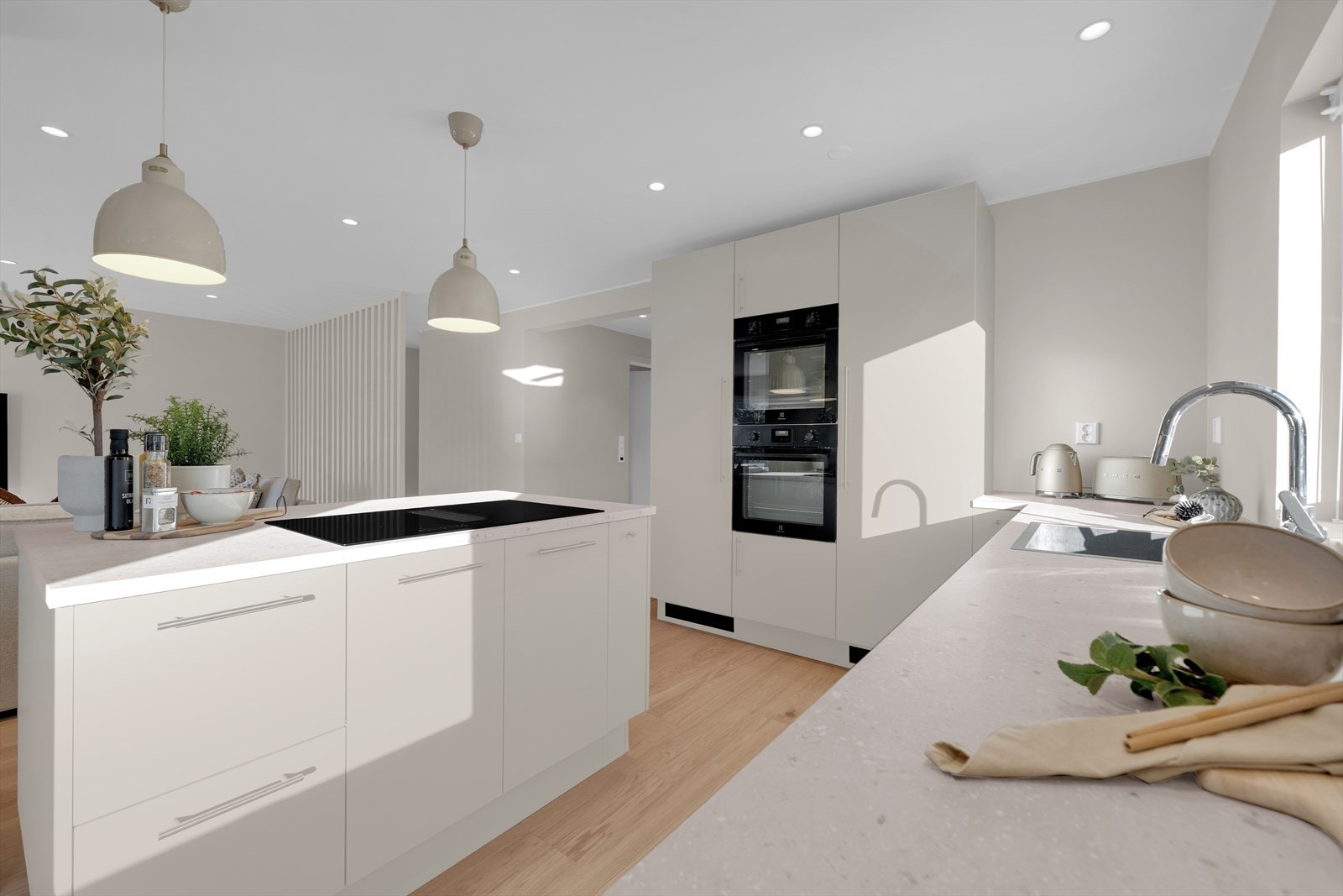 Kjøkkenet preges av moderne, beige glatte fronter som harmonerer perfekt med laminerte benkeplater i imitert stein. Galleribilde