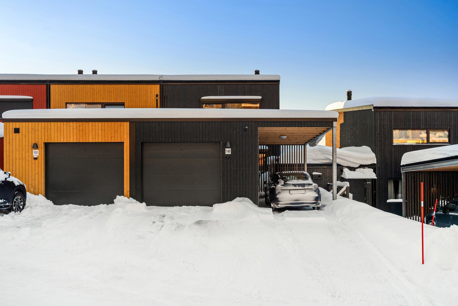 Boligen har endebeliggenhet på rekka (sort kledning).