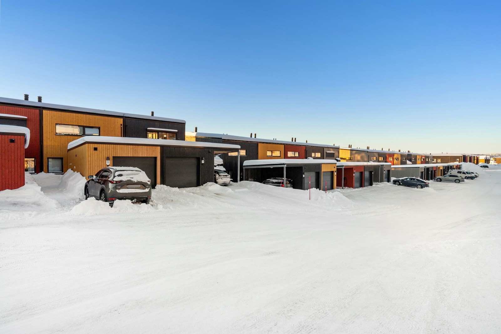 Boligene i feltet er oppført i ulike farger på kledning - dette skaper et livlig og vibrant bomiljø i nabolaget.