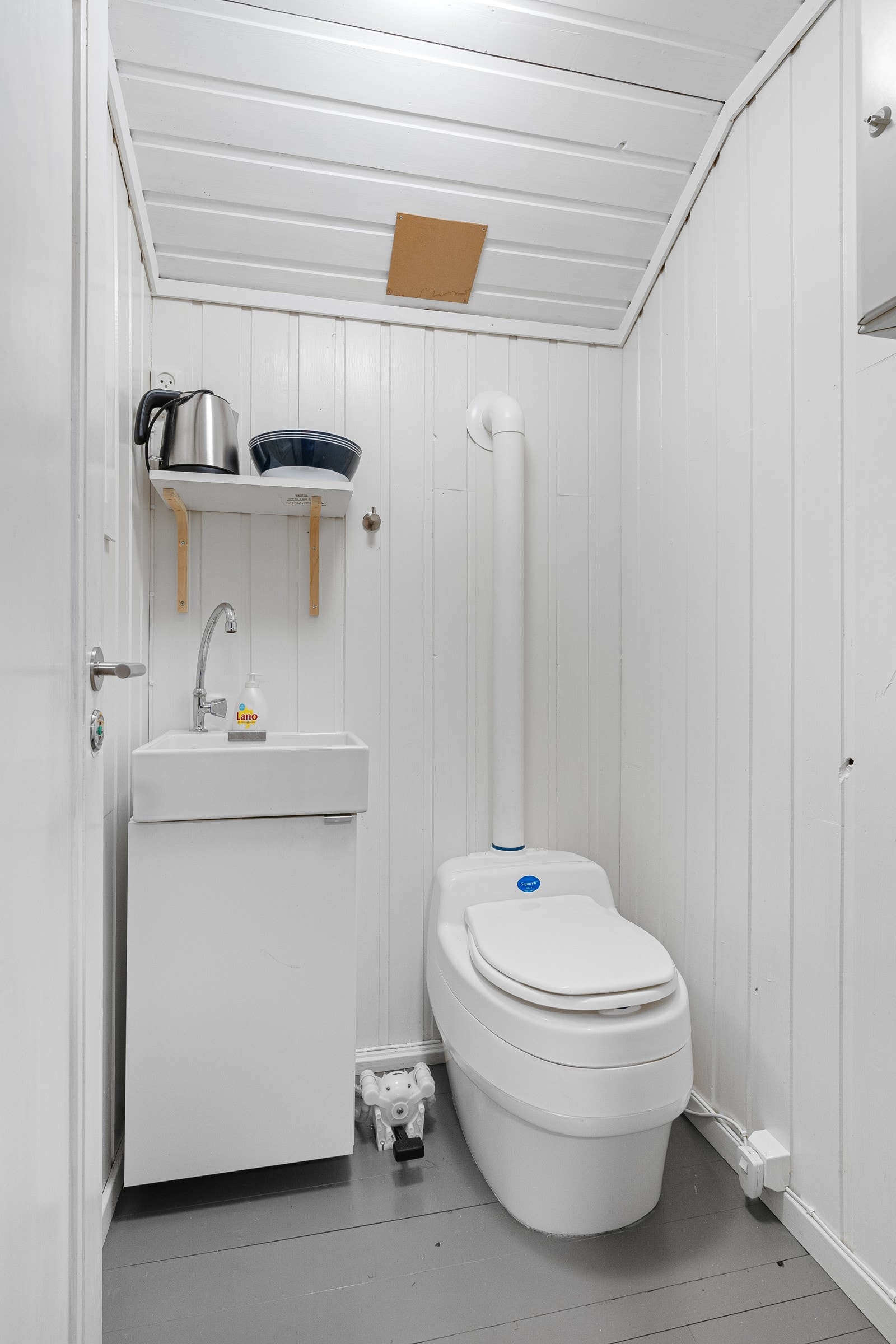 Toalettrom med innredning. Vask med fotpumpe og tett vanntank. Galleribilde