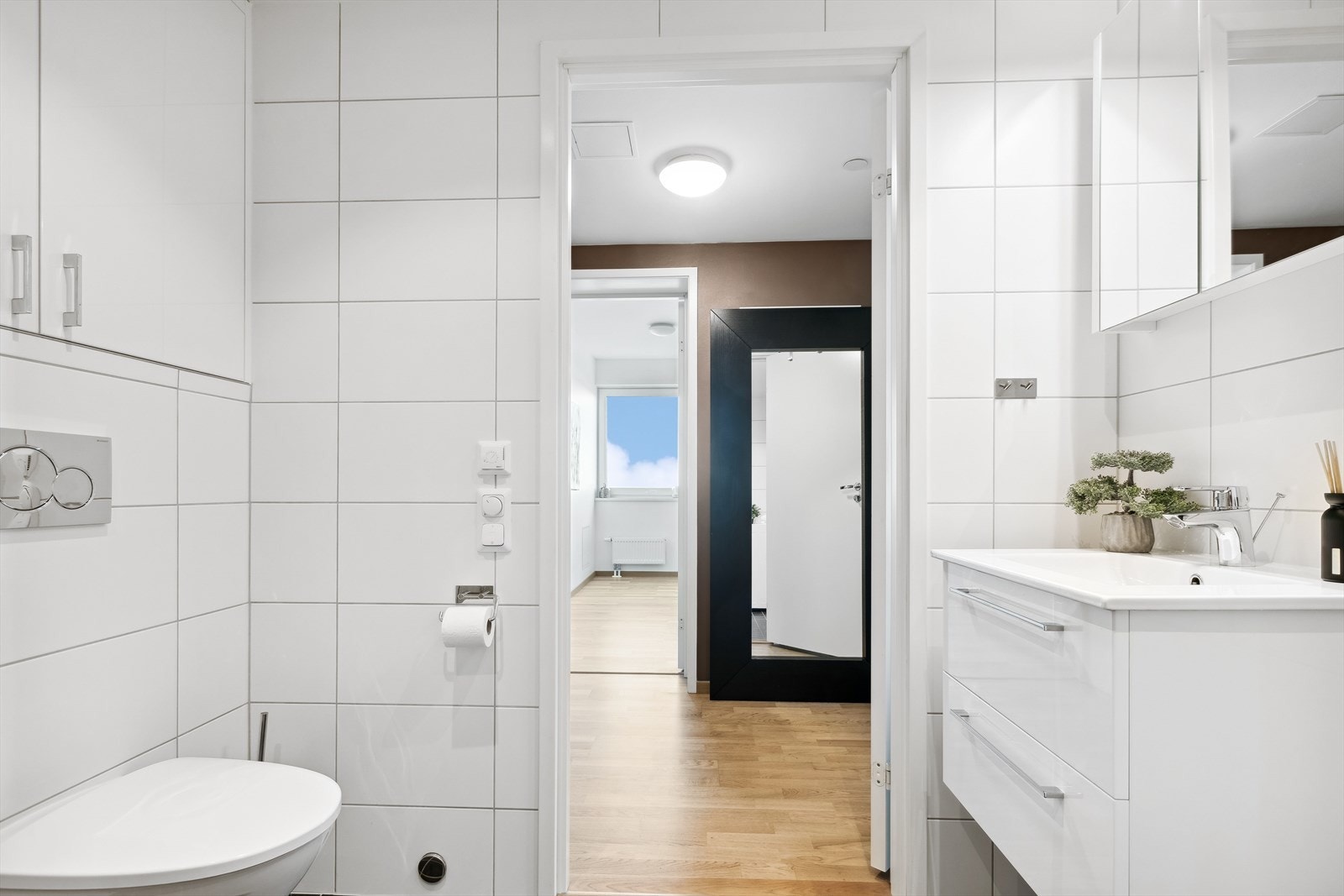 Baderommet er delikat og innbydende med hvite høyglansfronter. Galleribilde