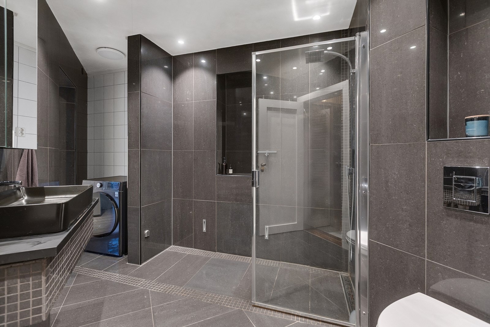 Romslig dusjsone og helhetlig, moderne baderomsuttrykk. Galleribilde