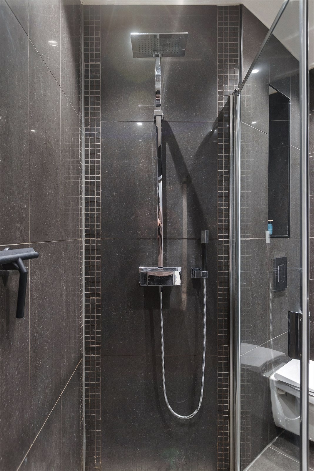 Delikat flislagt bad med dusjhjørne og moderne innredning Galleribilde