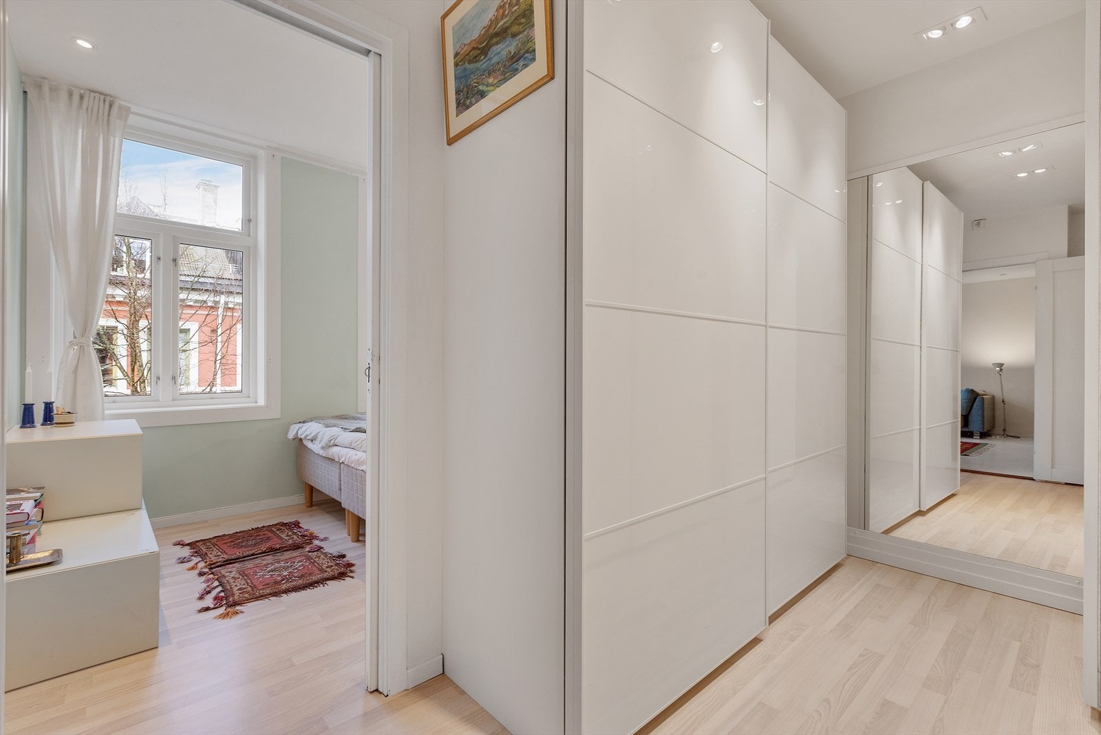 Omkledningsrom med garderobevegg/skaprekke og vindu som slipper inn godt med lys på soverom. Galleribilde