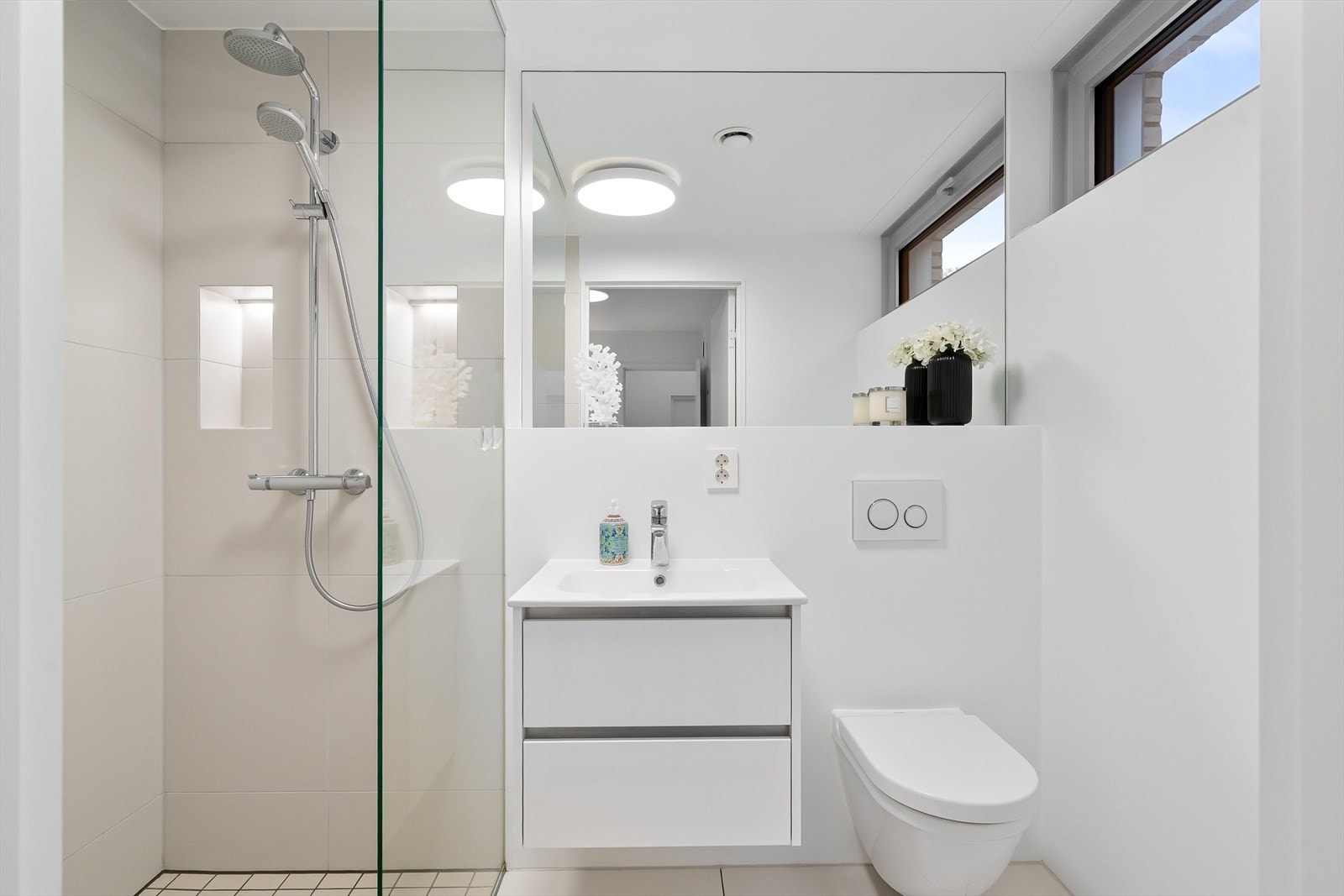 Bad 2 i 1. etasje med dusj i hjørne, vegghengt toalett og servant med innredning. Galleribilde