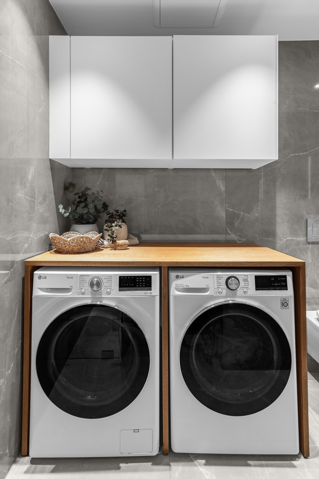 Svært praktisk løsning med overskap på vegg og vaskemaskin og tørketrommel under møbelsnekret benk av solid eik (kan medfølge etter nærmere avtale). Galleribilde