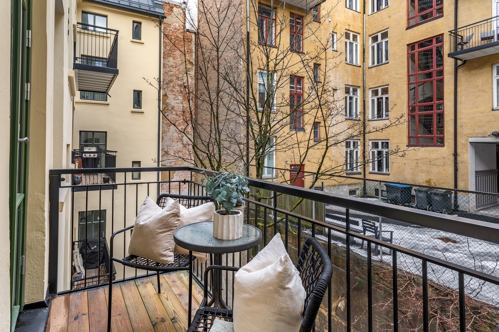 I sommerhalvåret er det et frodig tre og en grønn og vegg med klatreplanter på muren mot naboeiendommen. Galleribilde