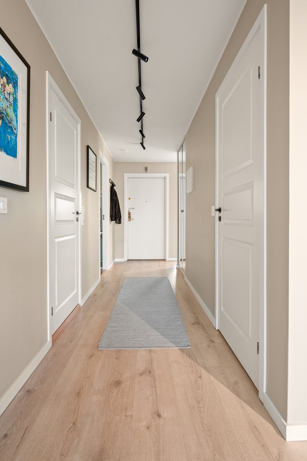 En lang gang forbinder entréen med stuen og gir en god romseparasjon. Galleribilde