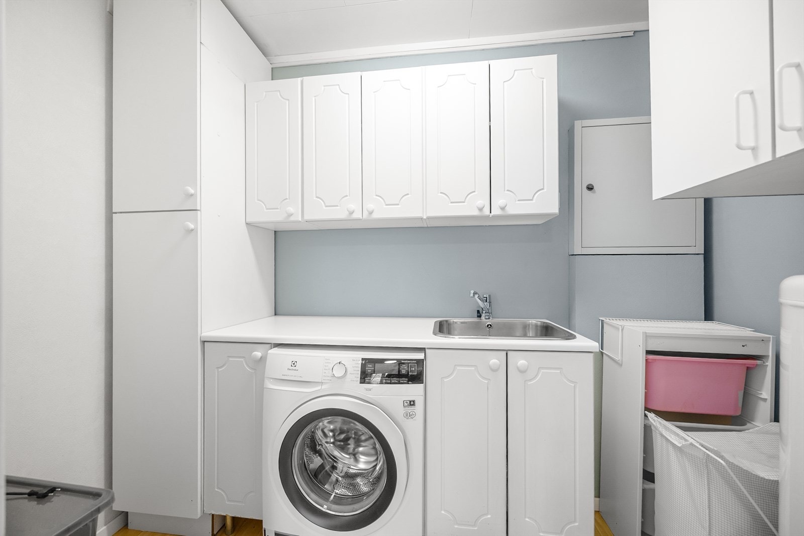 I forbindelse med kjøkkenet er det det skyvedør inn til vaskerom. Rommet er innredet med over- og underskap, høyskap, benkeplate med nedfelt vask, opplegg til vaskemaskin og varmtvannstank. Galleribilde