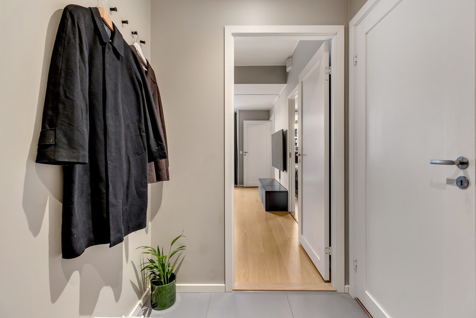 Entréen er lys og pen med fliser på gulv, og gir deg boligens gode atmosfære fra første steg inn. Galleribilde