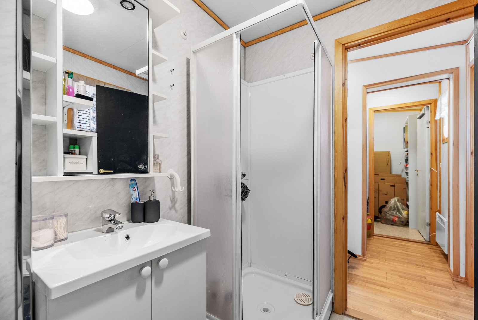 Baderom utstyrt med bereder, opplegg for vaskemaskin, servant, servantskap, dusjkabinett, wc og rørfordelingsskap. Galleribilde