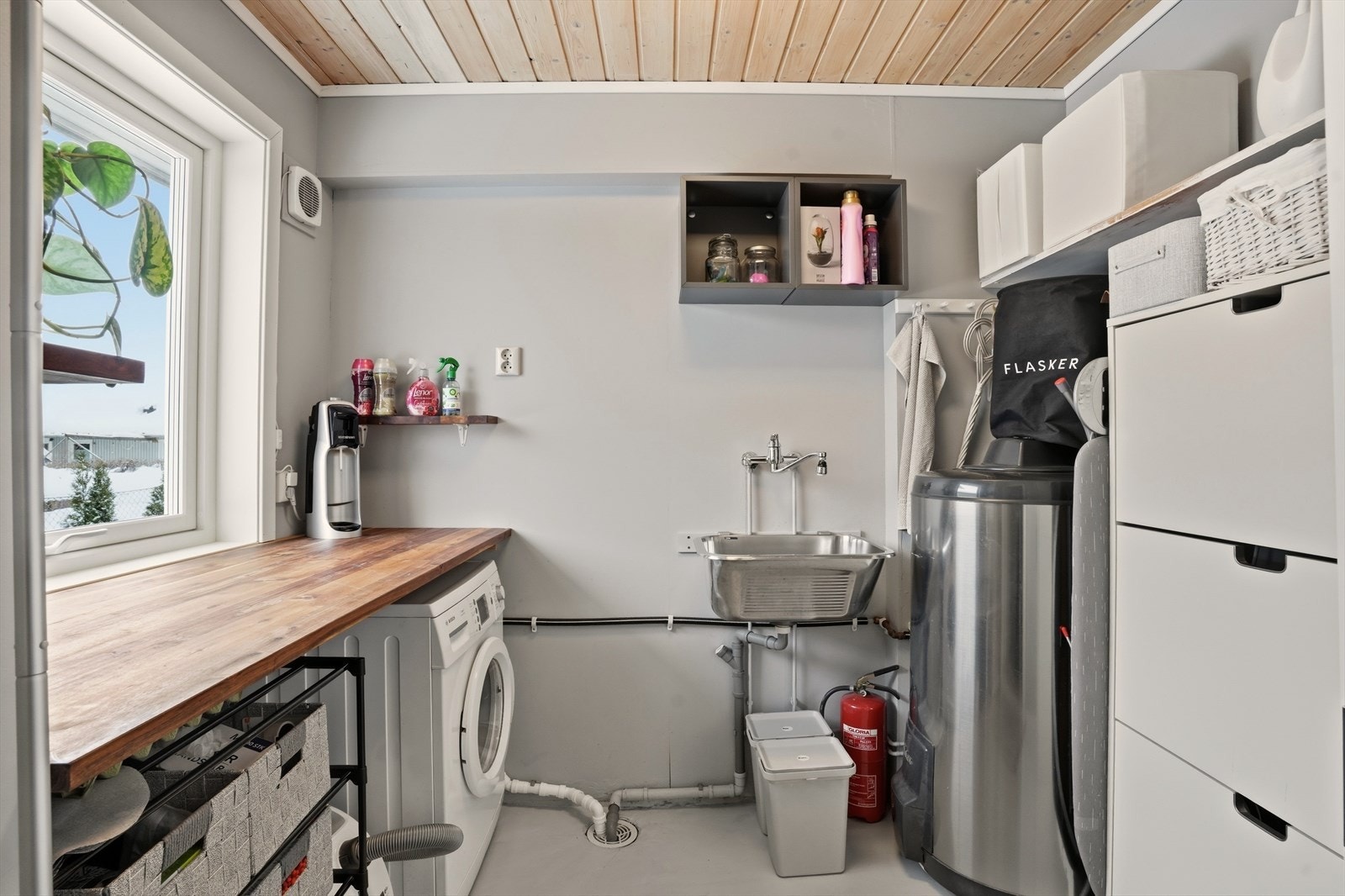 Praktisk vaskerom med opplegg for vaskemaskin, skyllekar og god plass til oppbevaring. Galleribilde