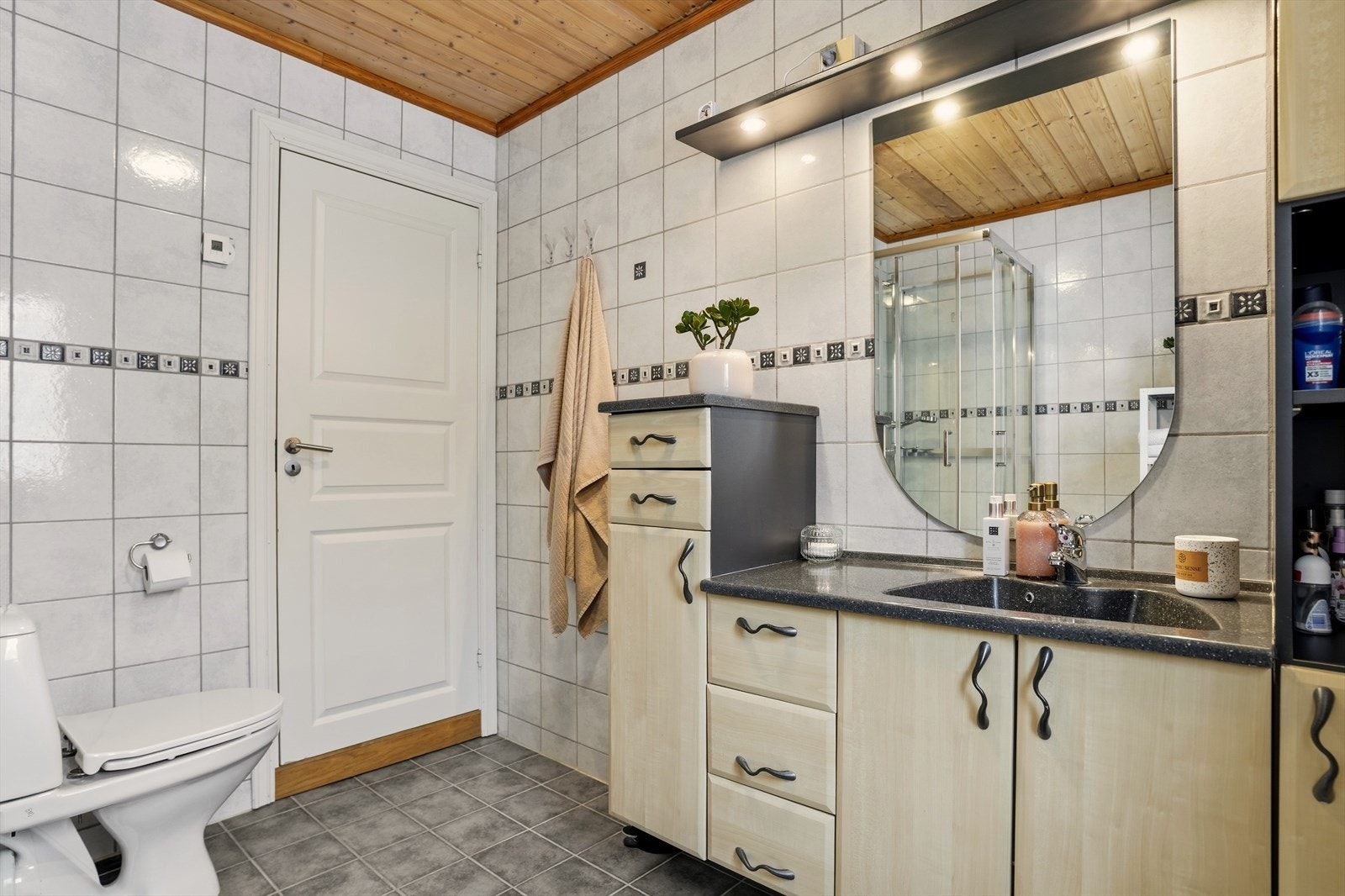 Romslig bad med flislagte overflater og praktisk innredning. Galleribilde