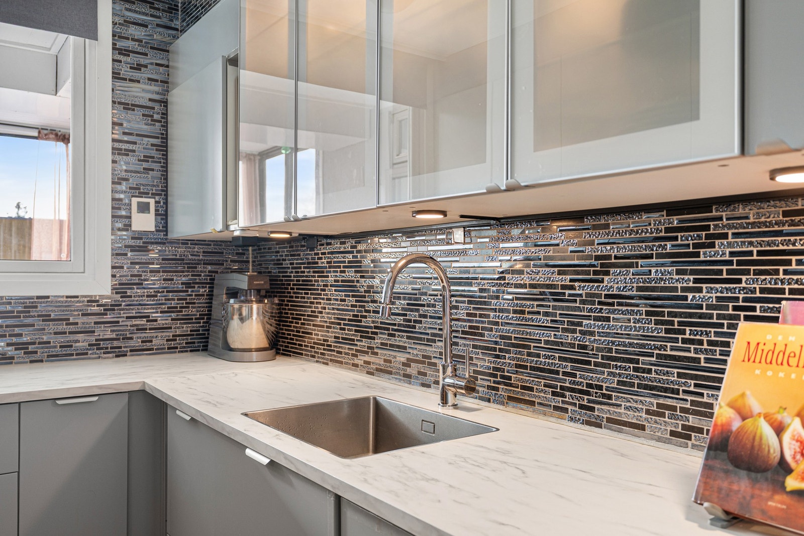 Kjøkkenet har integrerte hvitevarer som platetopp, stekeovn, kjøl/fryseskap og oppvaskmaskin. Galleribilde