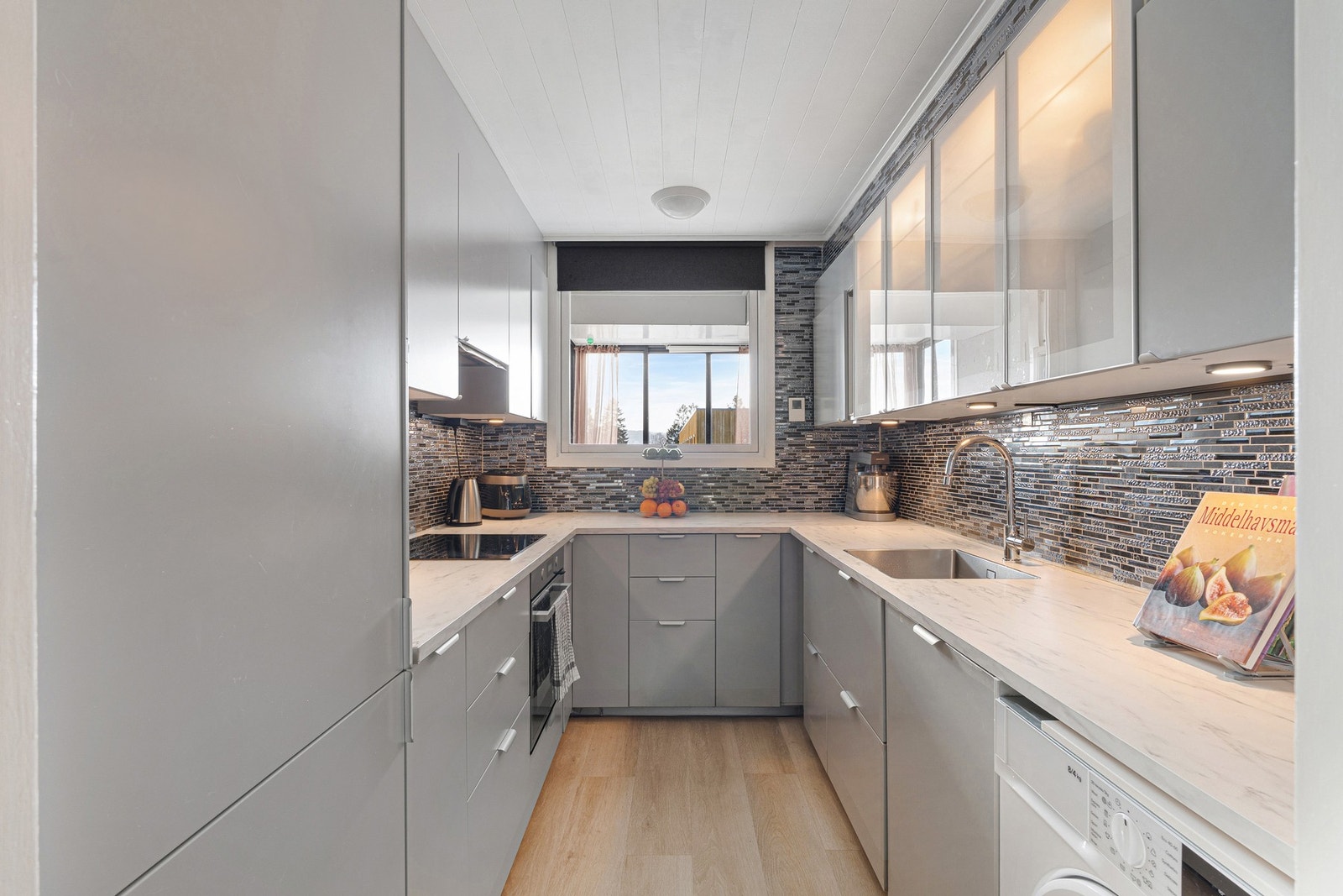 Pent og moderne kjøkken med mye skap- og benkeplass. Galleribilde