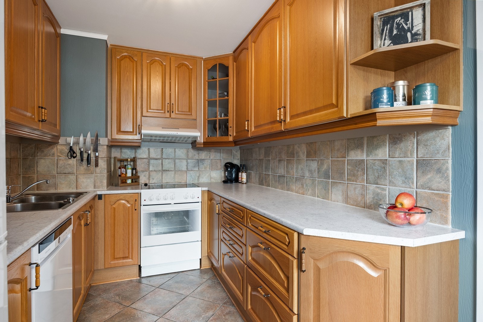 Kjøkkenet har profilerte fronter og laminat benkeplate. Frittstående kjøl/fryseskap og komfyr, underbygget oppvaskmaskin Galleribilde